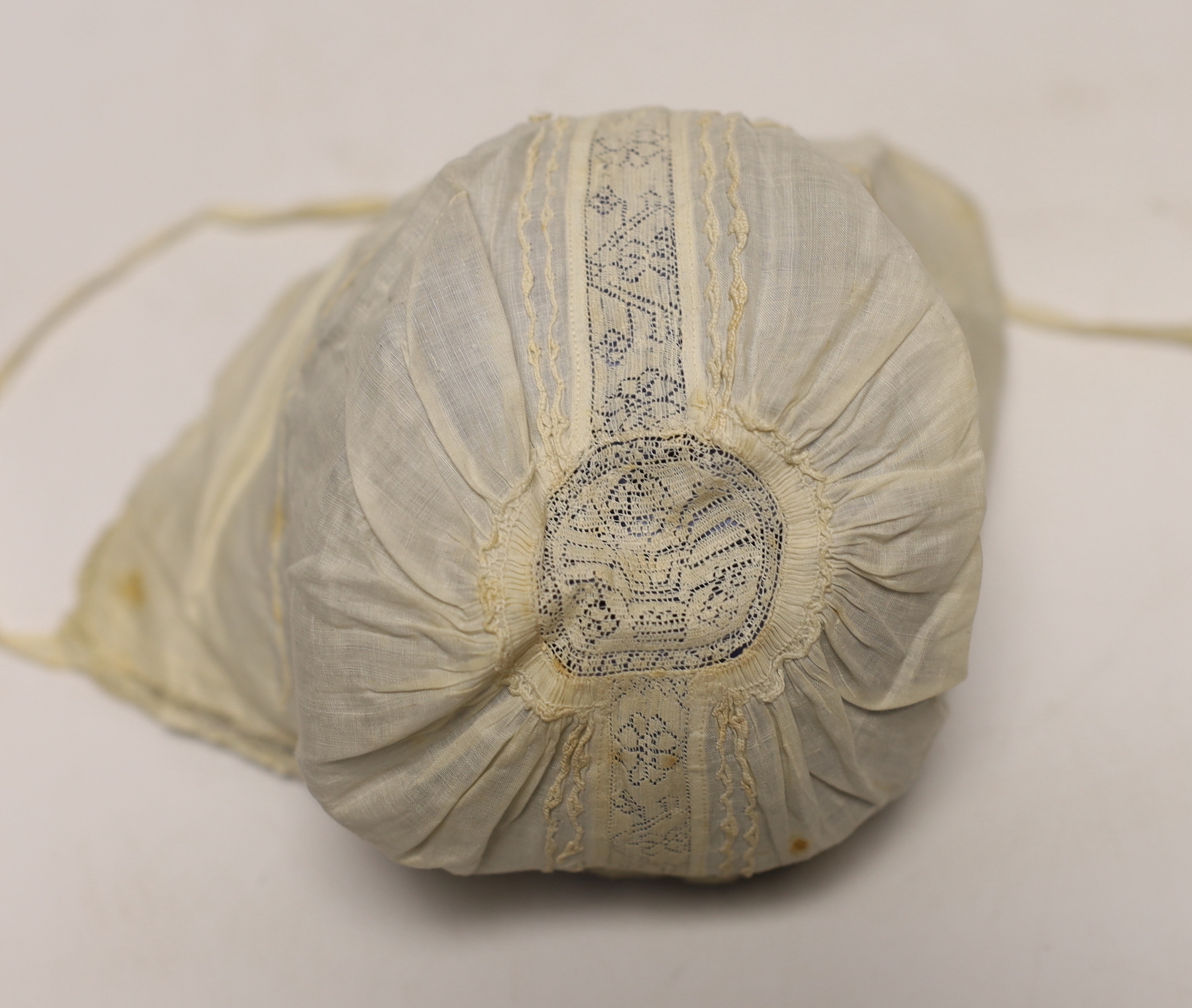 An early 18th century Hollie point insertion baby’s linen vest, three baby bonnets with Hollie point insertions and an early 18th century pair of Flemish bobbin lace lappets, a partly finished needlepoint length of lace,